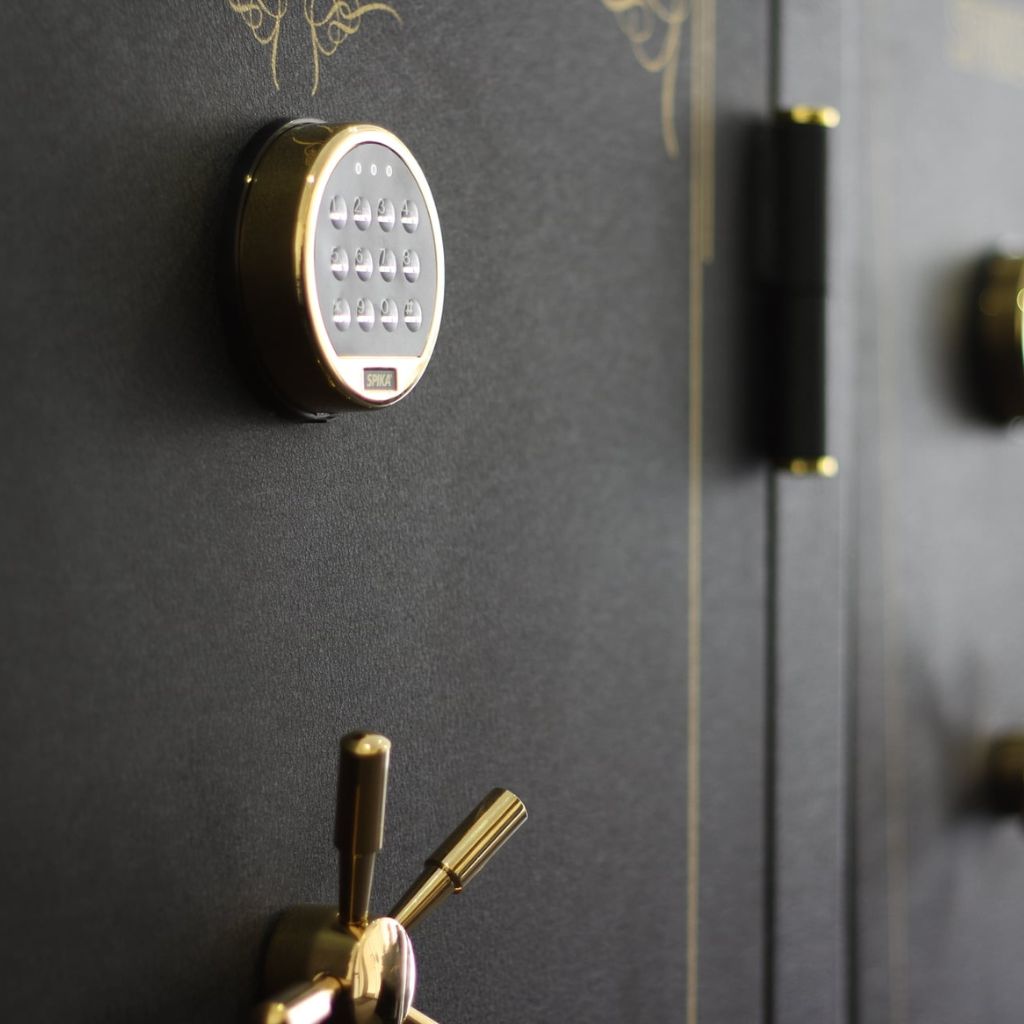 Close-up of a black gun safe with gold locks and keypad